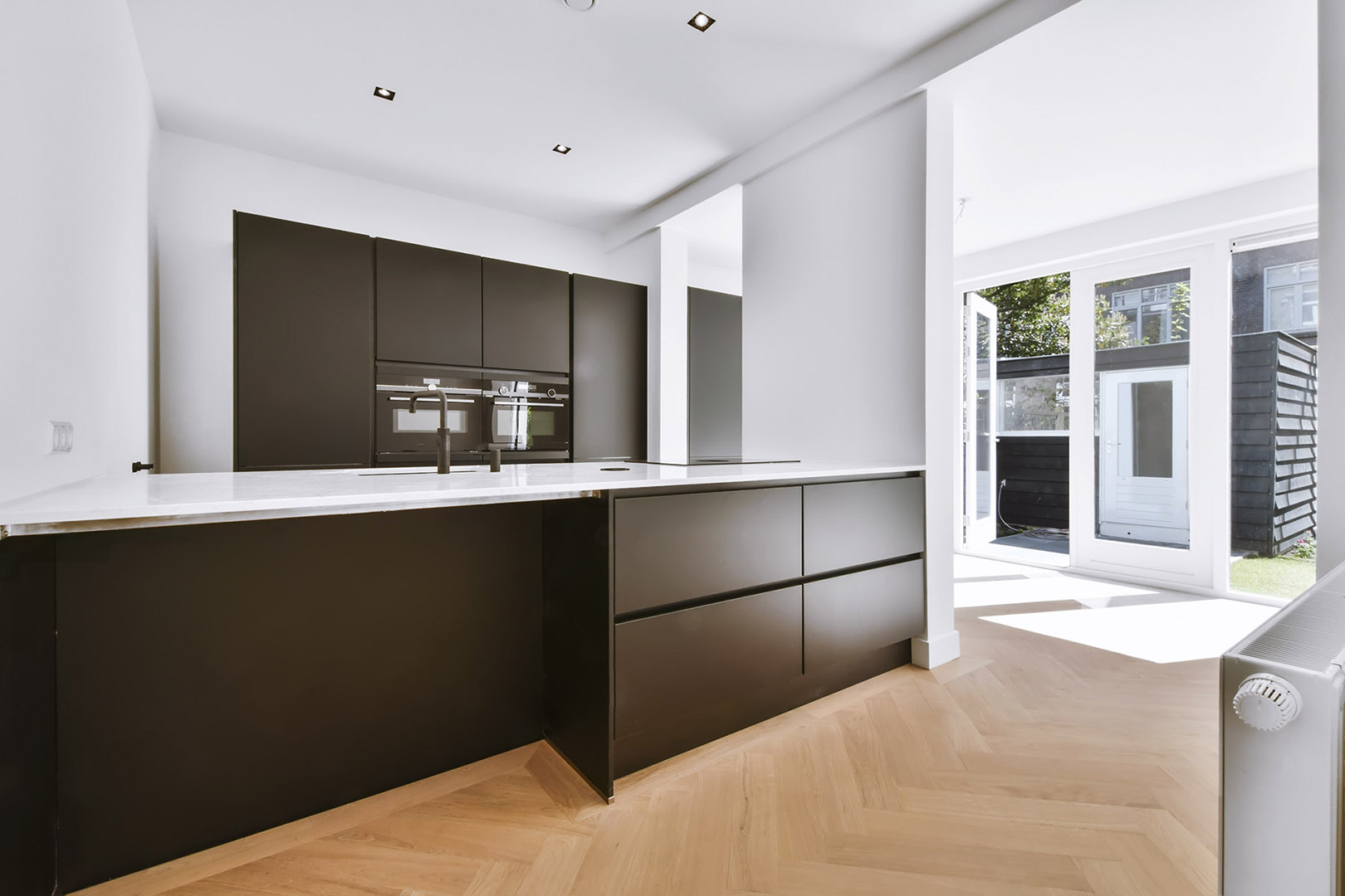 Stylish kitchen in daylight with a black kitchen set and white walls